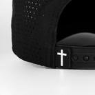 closeup of back of black hat showing cross label
