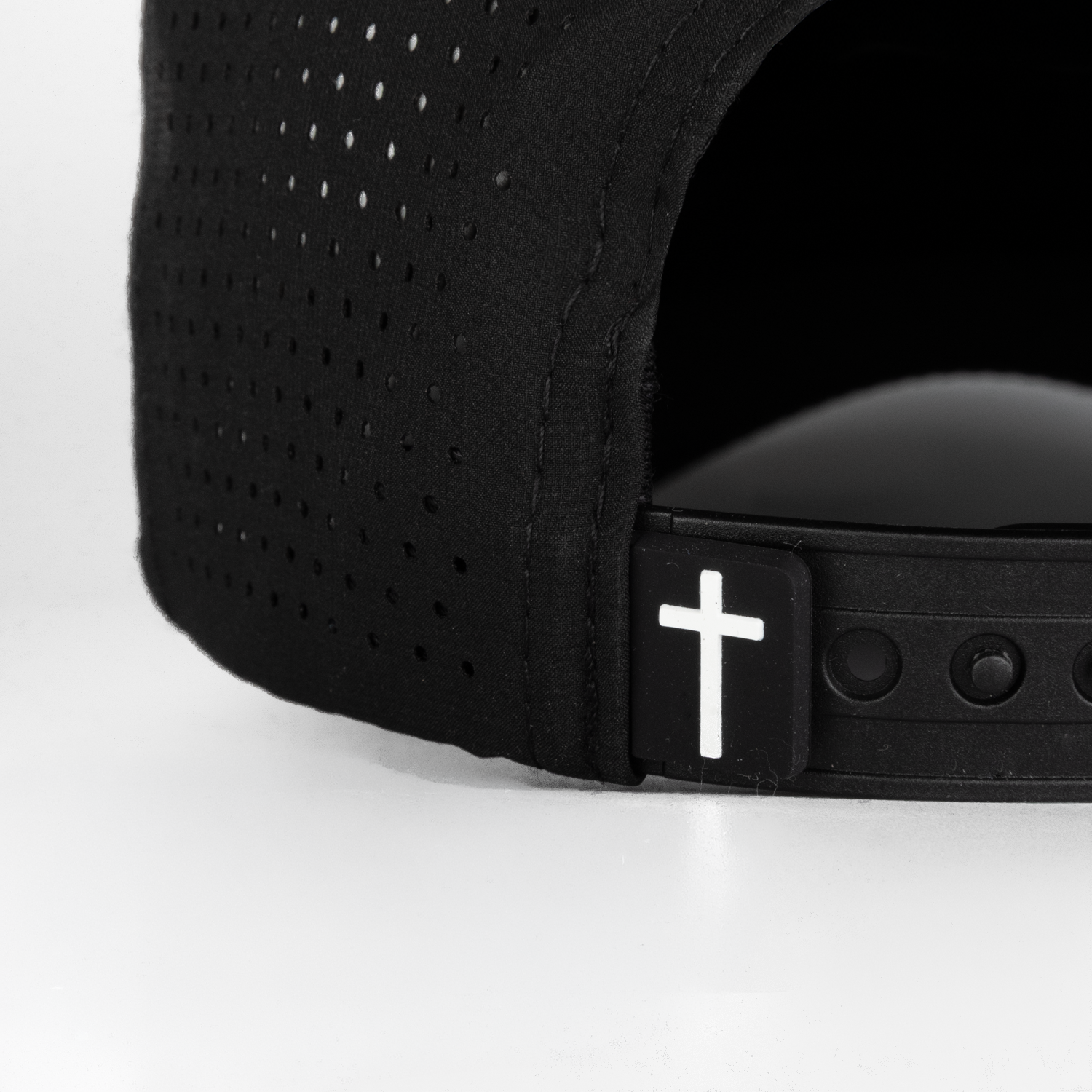 closeup of back of black hat showing cross label